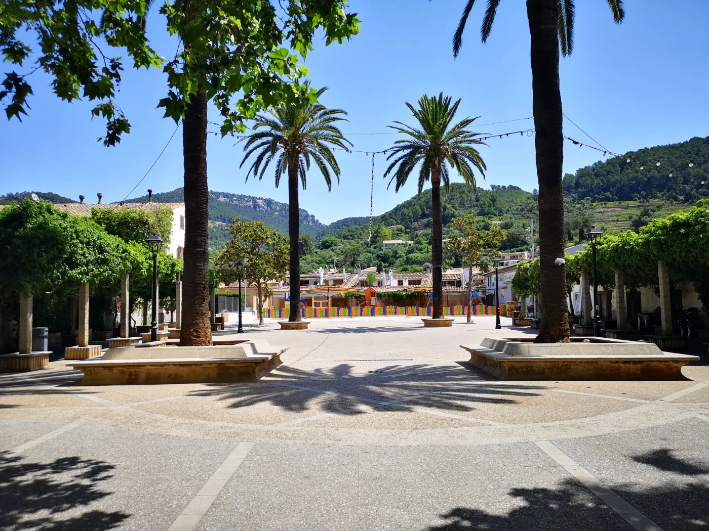 Central plads i Esporles by, med Tramuntana-bjerge i baggrunden, på øen Mallorca i Spanien.