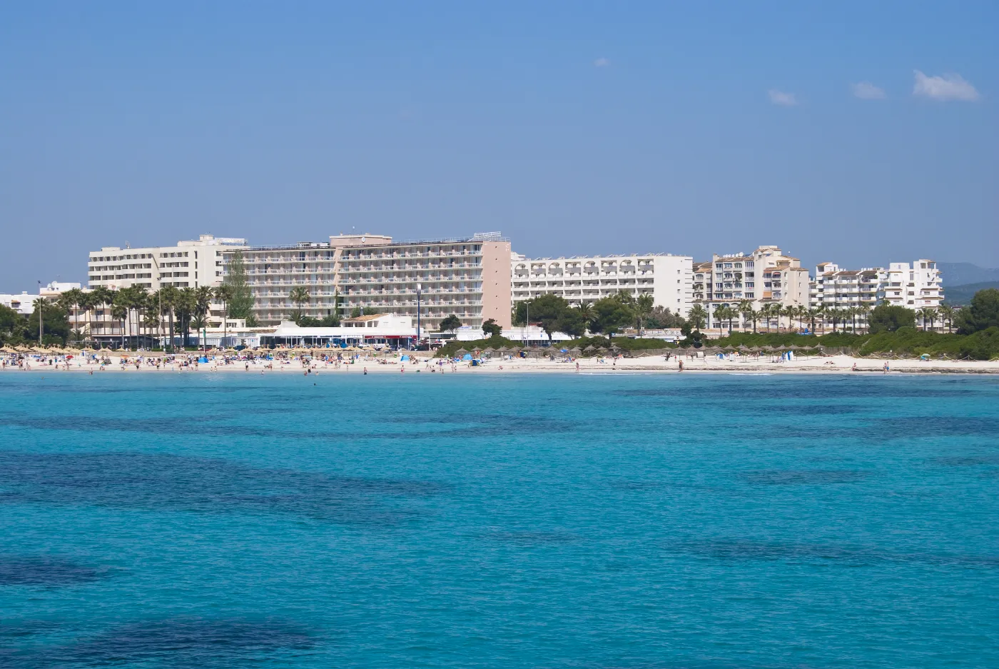 Strand med hoteller omkring i byen Sa Coma på ferieøen Mallorca i Spanien.