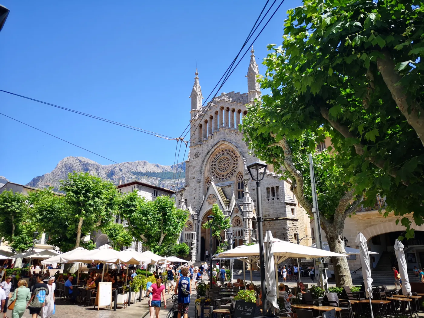 Sporvogn passerer torv foran kirke i byen Sóller på øen Mallorca i Spanien.