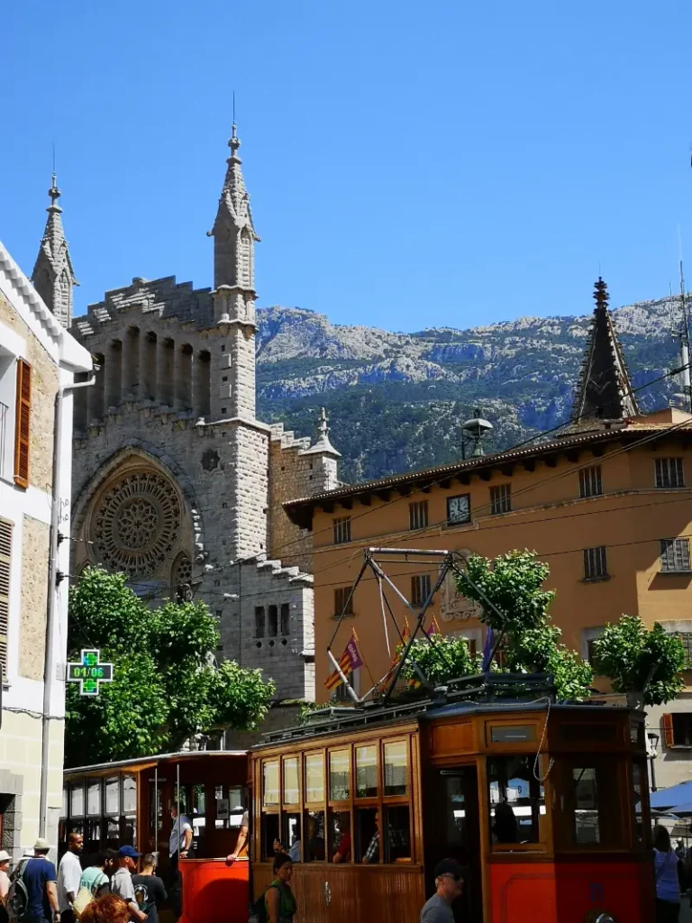 Torv med kirke i Sóller by på Mallorca, med bjerge i baggrunden.