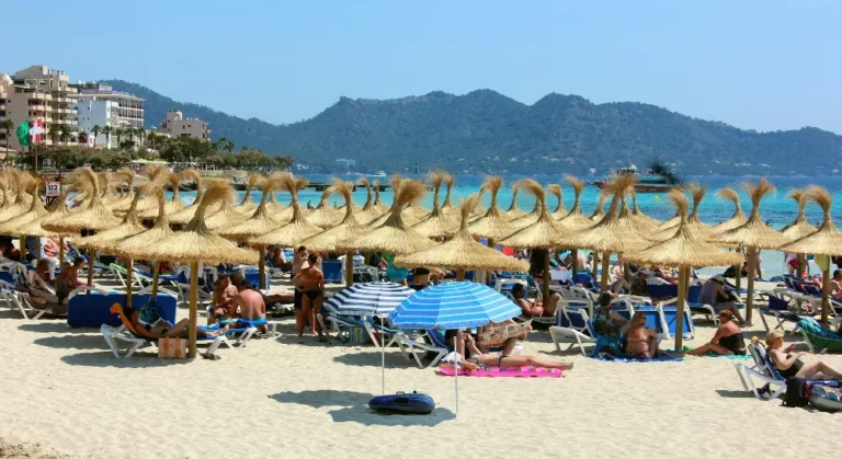Turister hygger sig på en strand på øen Mallorca en sommer i juni måned.