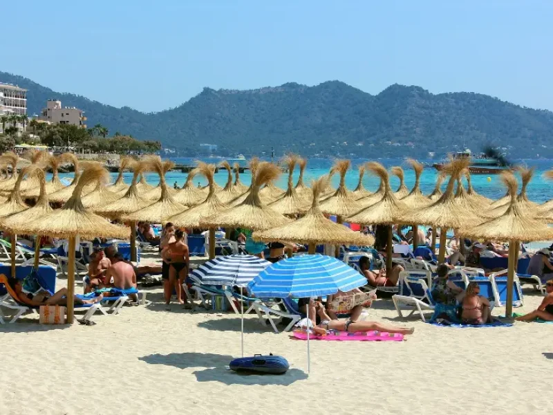 Turister hygger sig på en strand på øen Mallorca en sommer i juni måned.